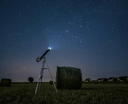 Telescope under a starry night sky
