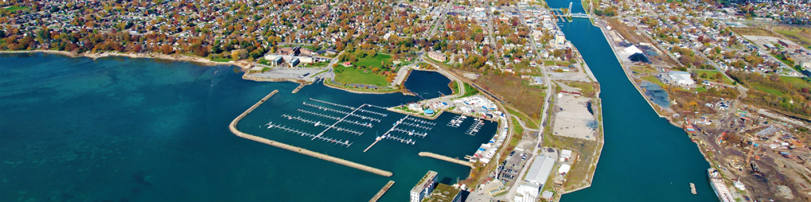 Aerial view of a marina and waterfront with boats, surrounded by a vibrant urban landscape.